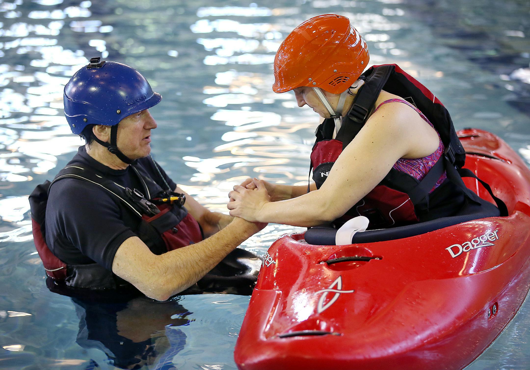 Jodi Martinez, a military veteran, held on to instructor Bill Kabitz of Team River Runner as she learned how to flip the kayak during a lesson Friday in Edina.