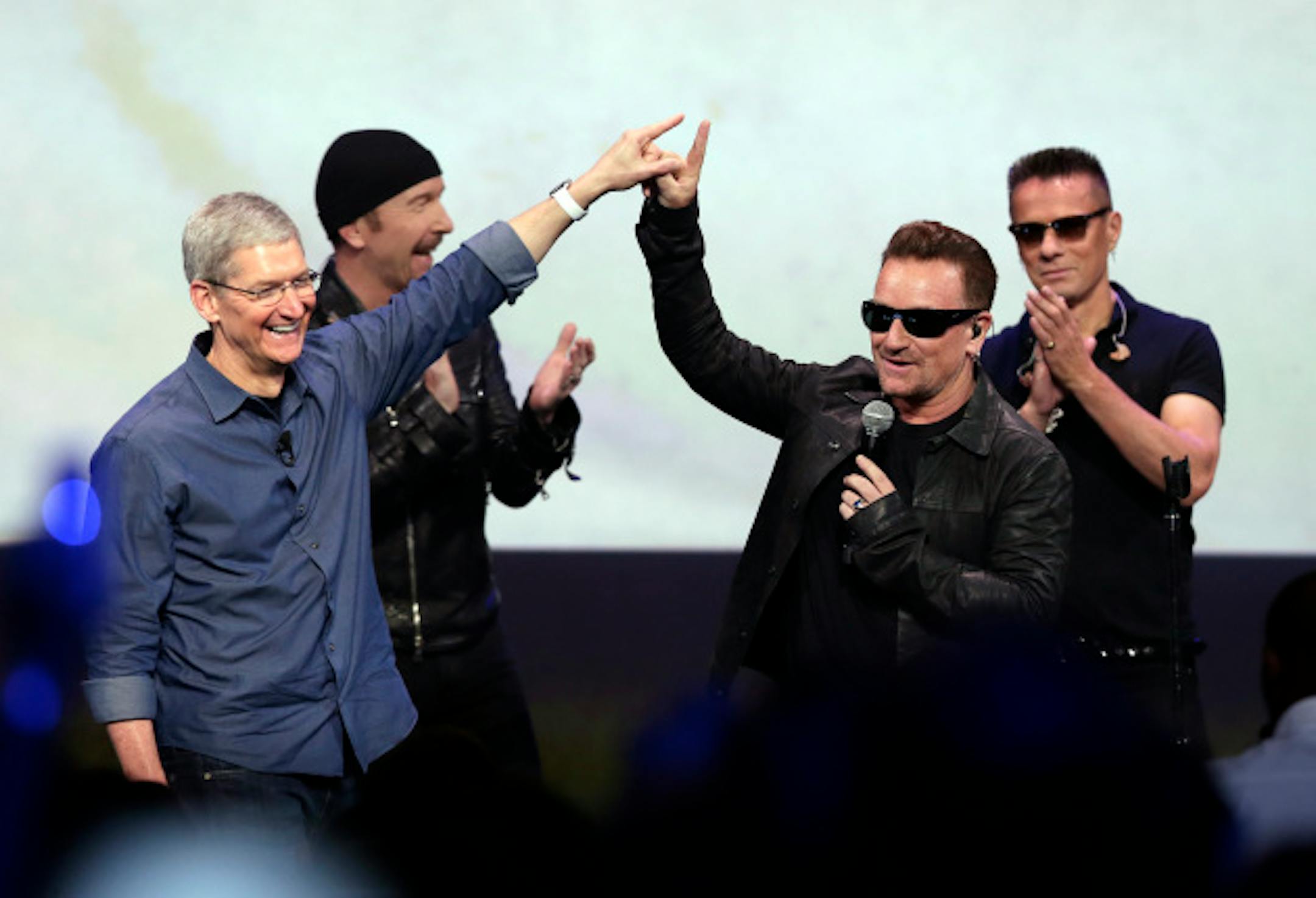 Apple CEO Tim Cook, left, thanked U2 for performing at his launch party and probably saving the world in Cupertino, Calif., earlier today. / AP Photo/Marcio Jose Sanchez