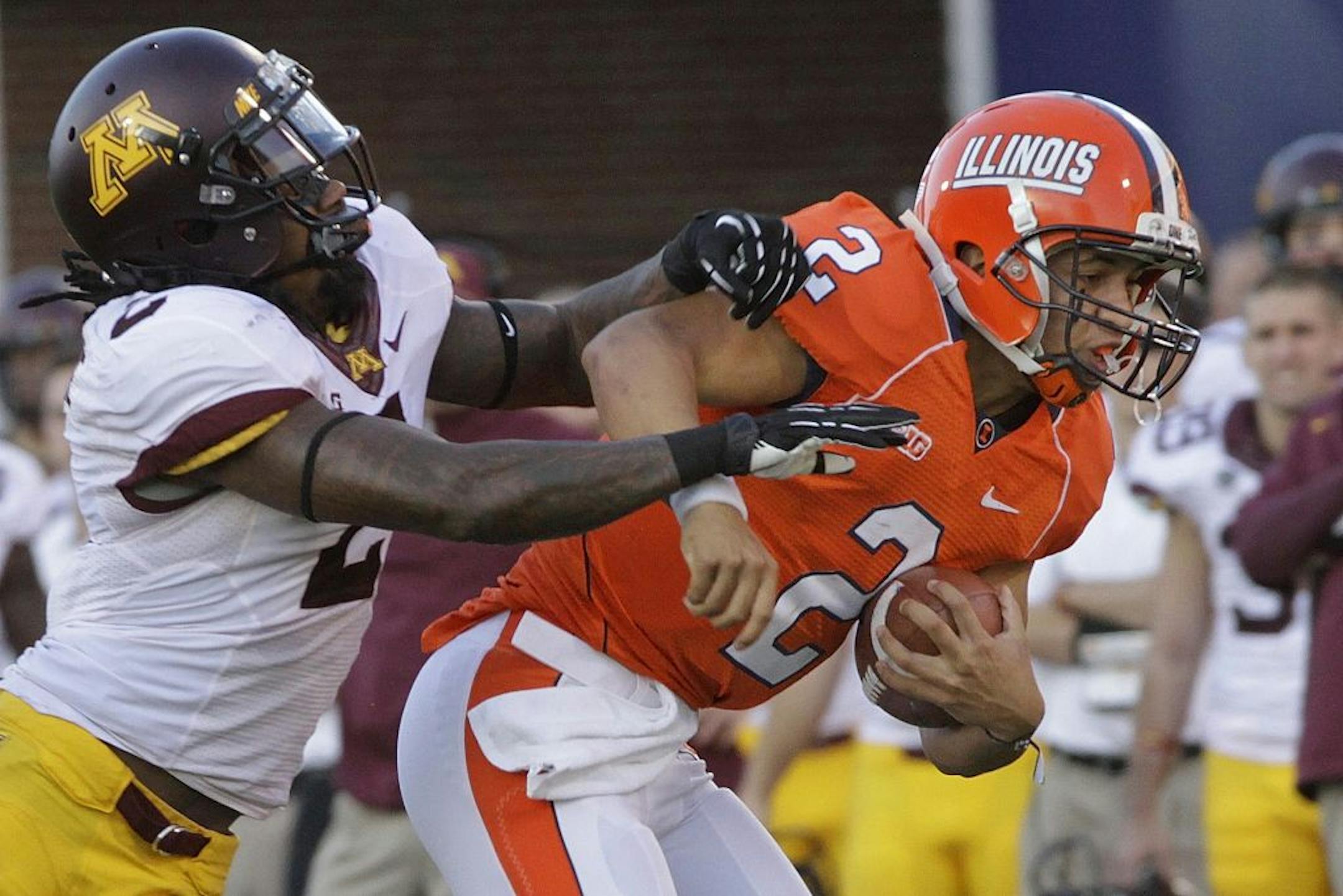 Illinois quarterback Nathan Scheelhaase is tackled by Minnesota defensive back Troy Stoudermire