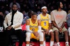 Lakers forward LeBron James, left, sits on the bench next to guard Russell Westbrook, forward Kent Bazemoreand forward Trevor Ariza