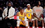 Lakers forward LeBron James, left, sits on the bench next to guard Russell Westbrook, forward Kent Bazemoreand forward Trevor Ariza
