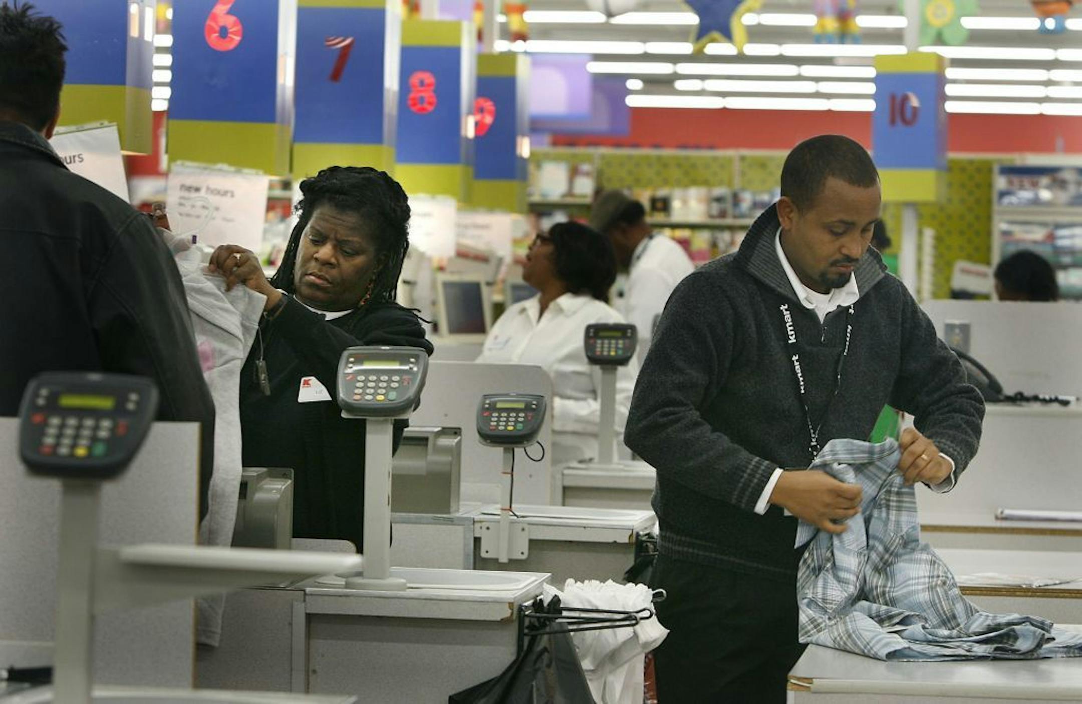 ELIZABETH FLORES eflores@startribune.com November 27, 2008 - Minneapolis, MN - Kmart employees Liz Carmon, left, and Getachew Mechegia, cq, worked the cashiers during an early morning shift at Kmart. Regional manager Dan Lawler said they were at full capacity with employees and that there were at least 50 people when the doors opened at 7 a.m., and that electronics were the most popular buys.