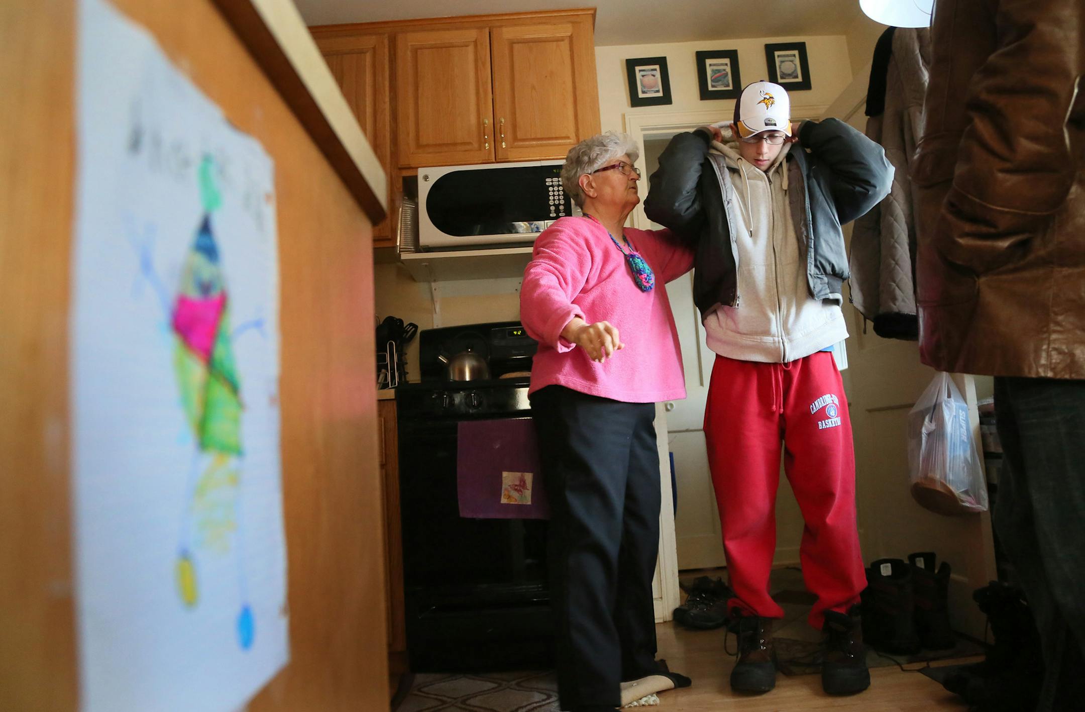 Here, Cory, 18, gets help getting his coat on from grandmother Michelle Robinette before heading to a birthday party of a friend with an aide Thursday, Feb. 12, 2015, in Cambridge, MN. Cory and his sister Brianna are twins and both have fetal alcohol syndrome and have lived with foster mom Candy Hoover since they were young. Hoover has since adopted them. They have severe mental impairments, and need help with their homework and even basic tasks, such as buttoning their shirts. However, Brianna