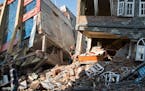 A rescue worker stands beside buildings that collapsed in an earthquake in Kathmandu, Nepal, Tuesday, May 12, 2015. A major earthquake has hit Nepal n