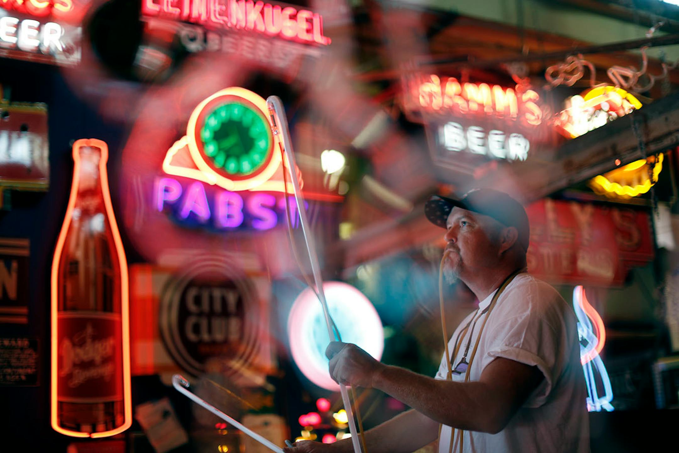 Matt Thompson, of Skyline Neon bends and shapes a glass tube using a gas flame for heat, and blowing into the tube through a tube/hose so that it retains its cylindrical shape during the process in his studio Wednesday August 17, 2016 in Minneapolis, MN.