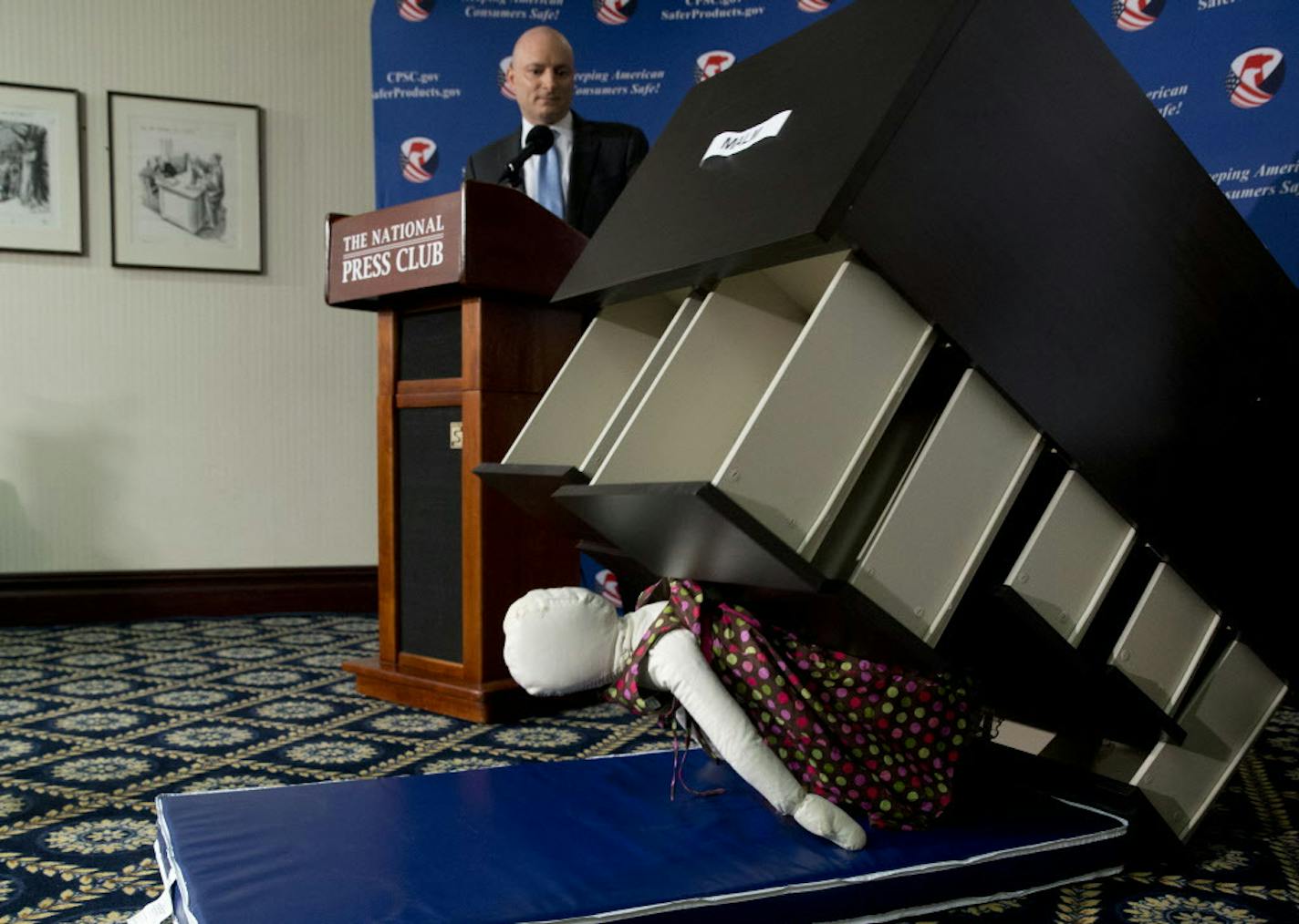 Consumer Product Safety Commission (CPSC) Chairman Elliot Kaye watches a demonstration of how an Ikea dresser can tip and fall on a child during a news conference at the National Press Club in Washington, Tuesday, June 28, 2016. Ikea is recalling 29 million chests and dressers after six children were killed when the furniture toppled over and fell on them. (AP Photo/Carolyn Kaster)