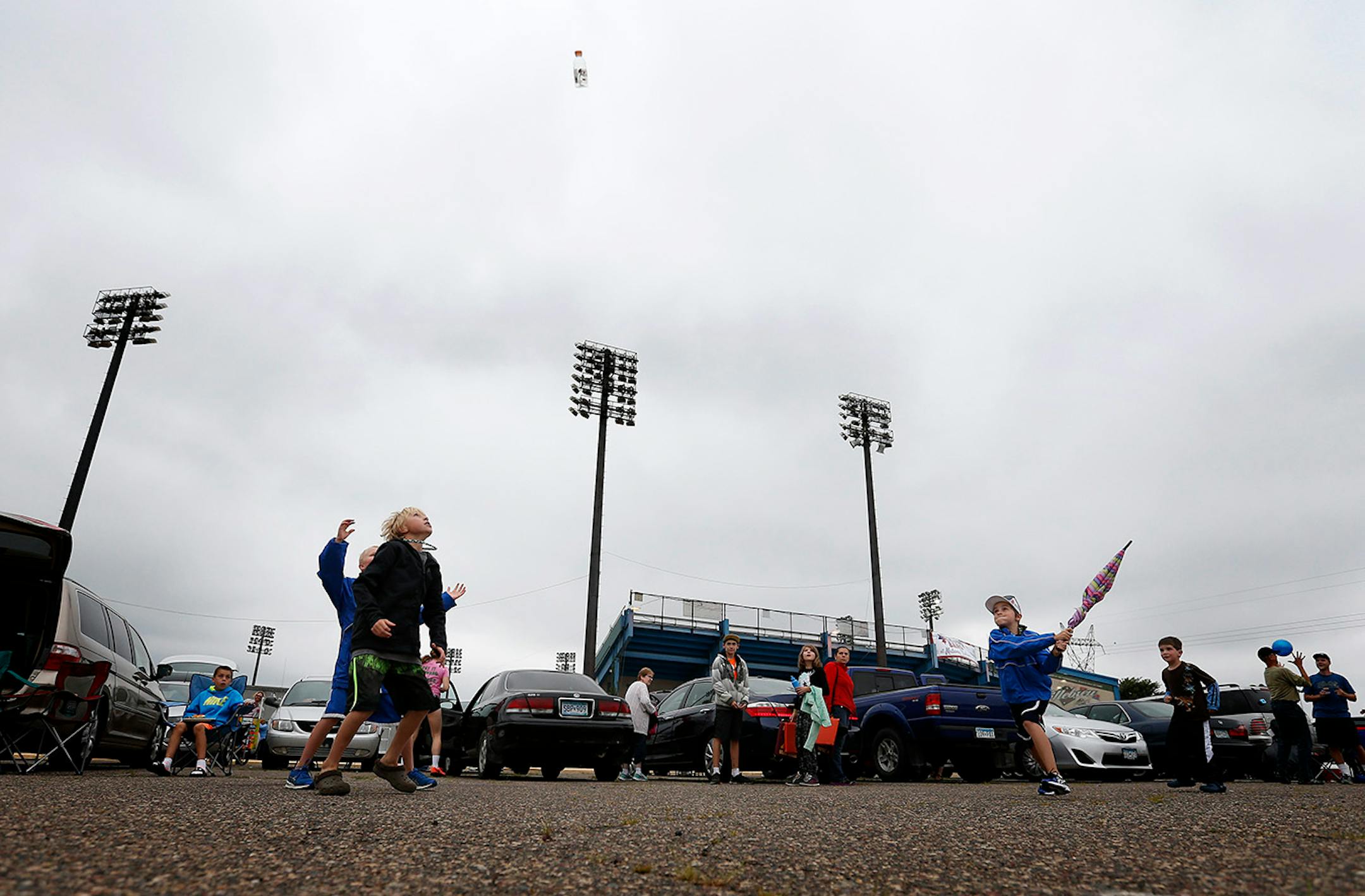 Josh Bertrand, 11, of Inver Grove Heights used an umbrella and an empty plastic bottle to play baseball with friends while tailgating before the St. Paul Saints final game at Midway Stadium on Thursday night. ] CARLOS GONZALEZ cgonzalez@startribune.com - August 28, 2014, St. Paul, Minn., Midway Stadium, St. Paul Saints baseball vs. Winnipeg - Final Saints game at Midway Stadium