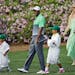 Tiger Woods walks with his children Sam and Charlie and Lindsey Vonn during the Par 3 contest at the Masters golf tournament Wednesday, April 8, 2015,