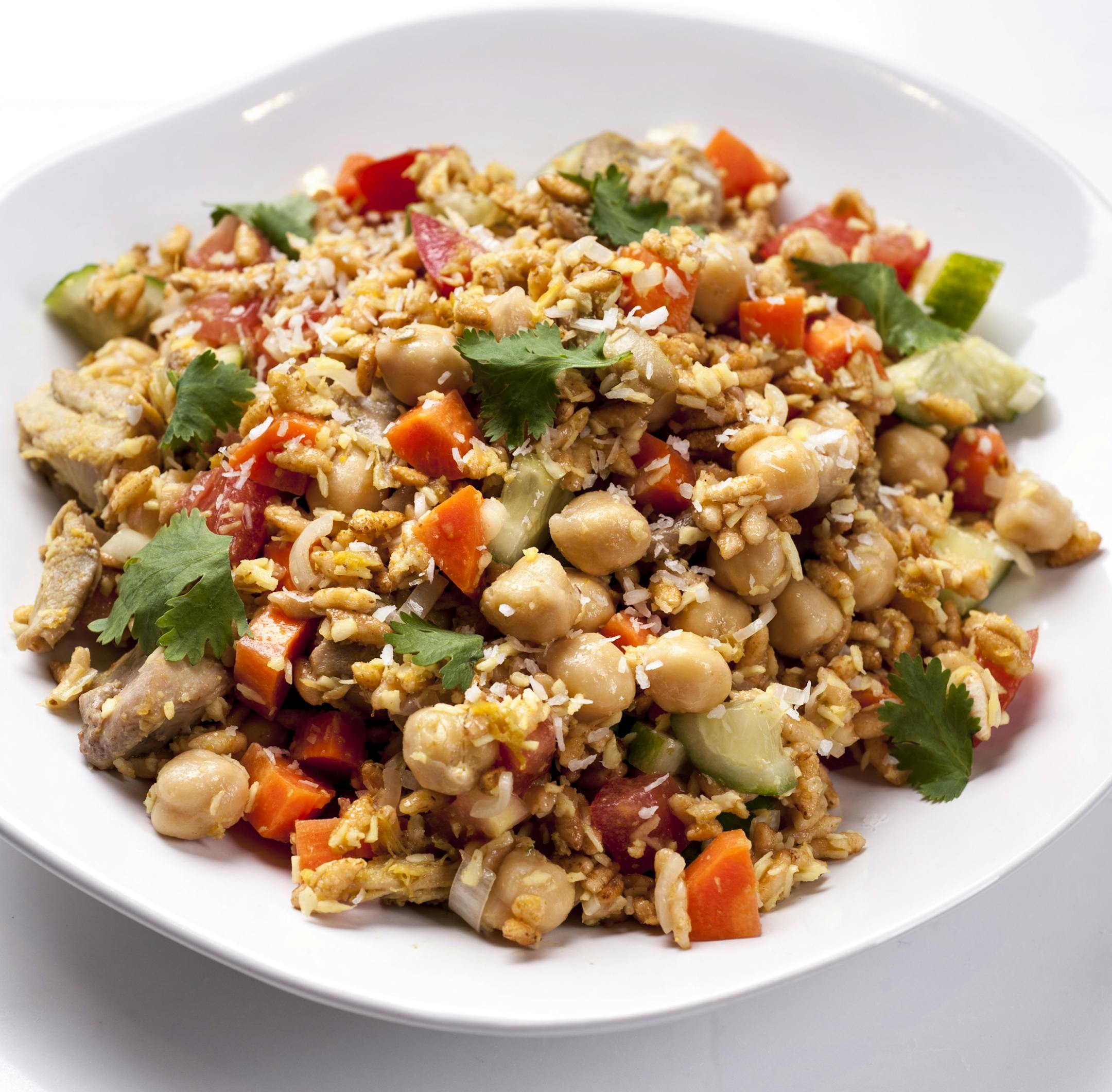 A dish of puffed rice with chicken and chickpeas, in New York, July 16, 2013. The trick to making a good whole-grain dish is not letting the grain stand alone. (Karsten Moran/The New York Times) ORG XMIT: XNYT25