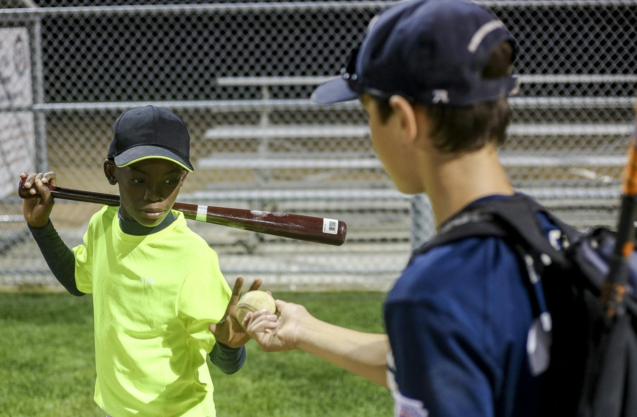 Vibel Aboue, left, receives a signed baseball from Robbinsdale All-Stars second baseman Oran Hinkle, right, after practice at Lakeview Terrace Park on Wednesday, August 3, 2016 in Robbinsdale.
