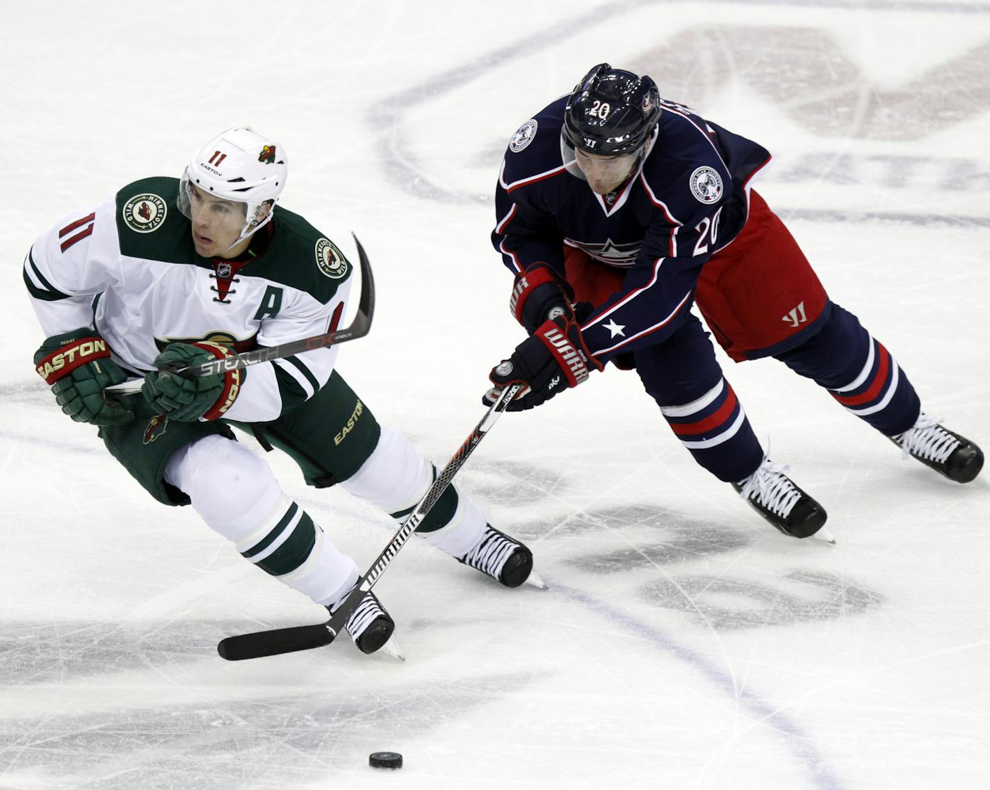 Minnesota Wild's Zach Parise, left, works for the puck against Columbus Blue Jackets' Brandon Saad during the third period of an NHL hockey game in Columbus, Ohio, Tuesday, Jan. 5, 2016. Minnesota won 4-2. (AP Photo/Paul Vernon)