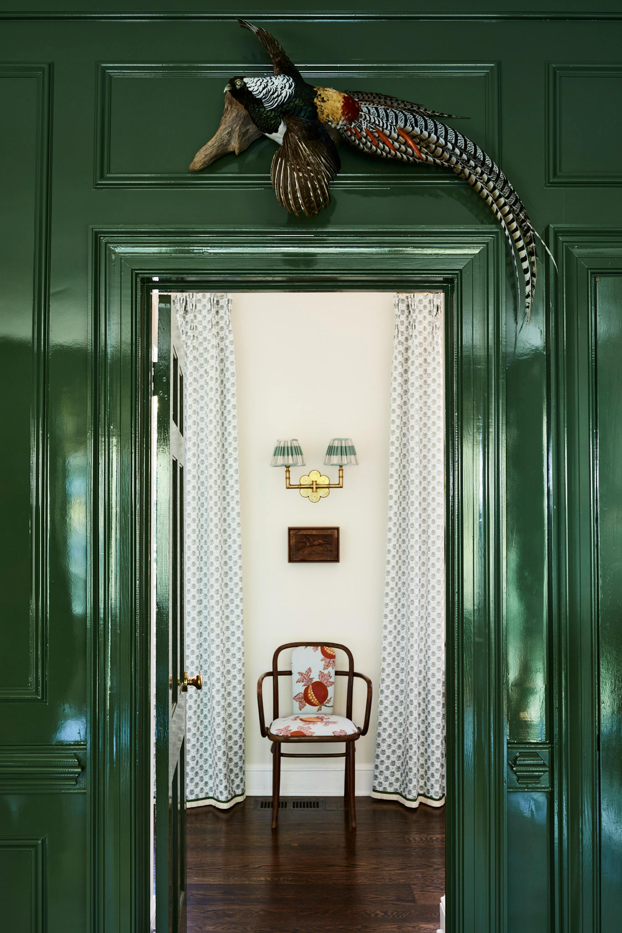A vintage taxidermy pheasant from Creel and Gow hangs above the library doorway. MUST CREDIT: Anna Williams
