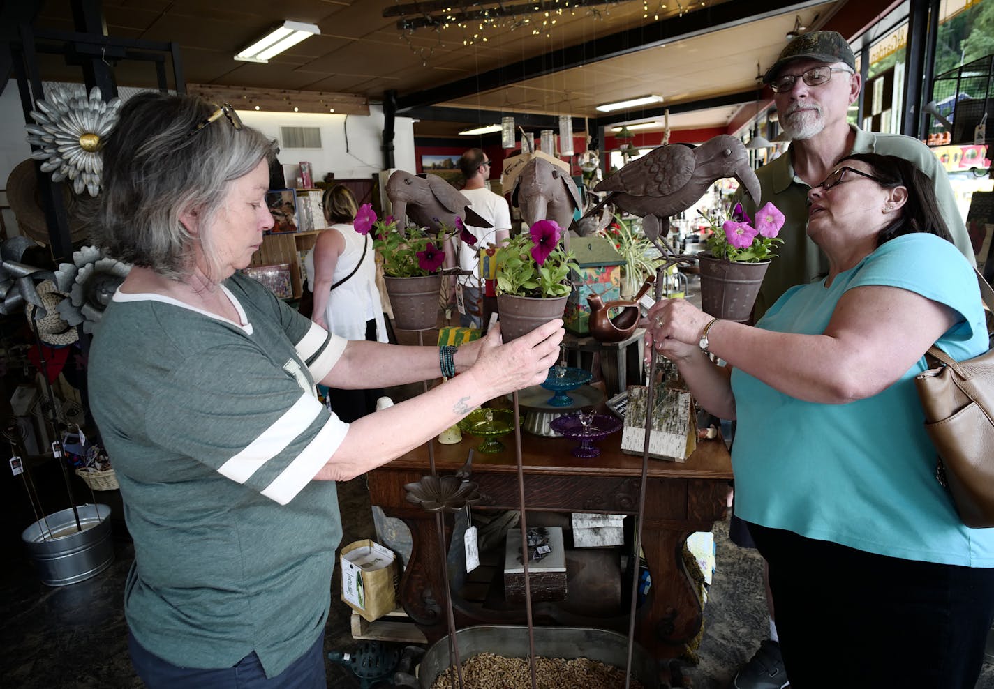 Sales associate Peggy Pribil, left, helped Steve and Beckie LeRoy choose a planter at the Stillwater Farm Store.