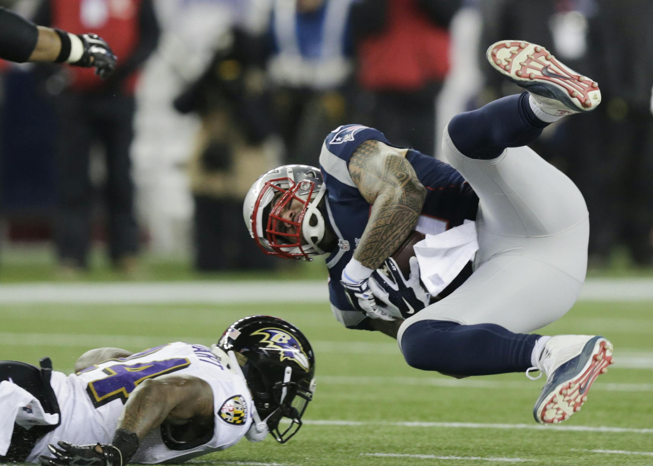 New England Patriots tight end Michael Hoomanawanui (47) goes flying after being hit by Baltimore Ravens free safety Darian Stewart, on the ground, in the second half of an NFL divisional playoff football game Saturday, Jan. 10, 2015, in Foxborough, Mass. (AP Photo/Charles Krupa)