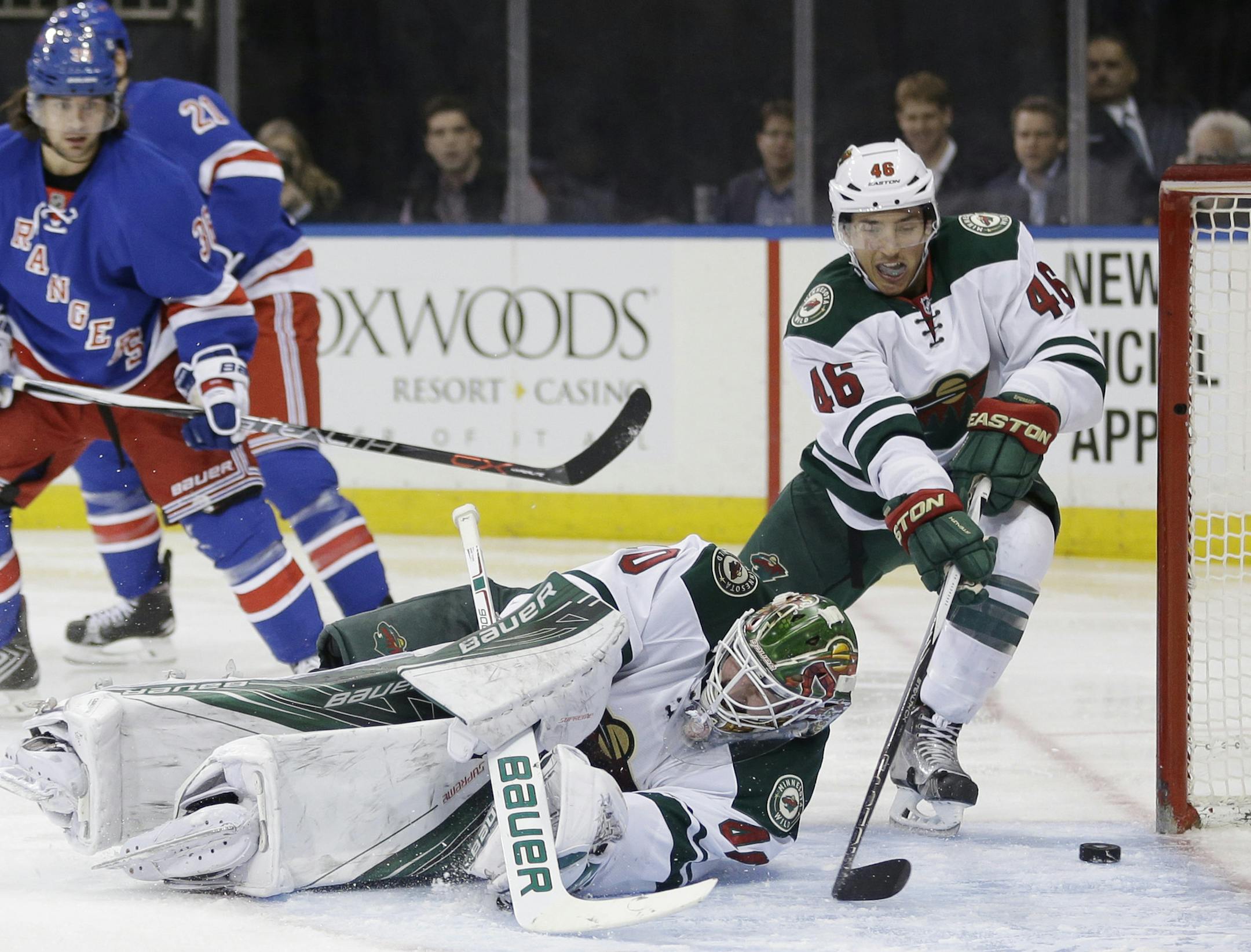 A shot by New York Rangers Ryan McDonagh moves past Minnesota Wild defenseman Jared Spurgeon (46), right, and goalie Devan Dubnyk (40) into the goal during the second period of the NHL hockey game, Thursday, Feb. 4, 2016, in New York. (AP Photo/Seth Wenig)