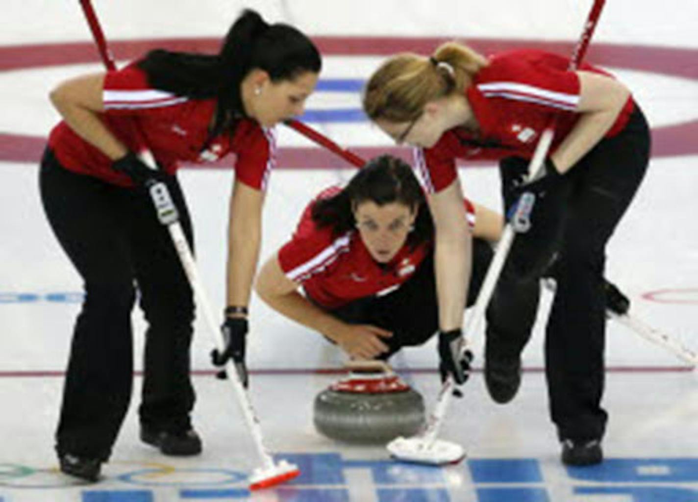 Switzerland's Carmen Kueng, center, delivered the stone to sweepers Carmen Schaefer, left, and Janine Greiner during women's curling competition against the United States at the 2014 Winter Olympics on Monday.