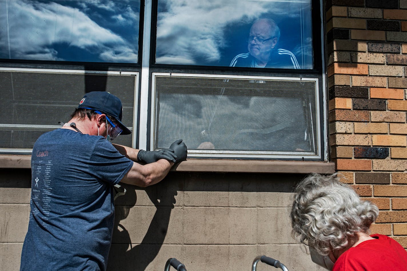 Jeff Johnson and his mother, Kathy Johnson, are visiting his father, Michael Johnson, at the North Ridge Health and Rehab nursing home in New Hope, Minn., Tuesday, May 19, 2020.