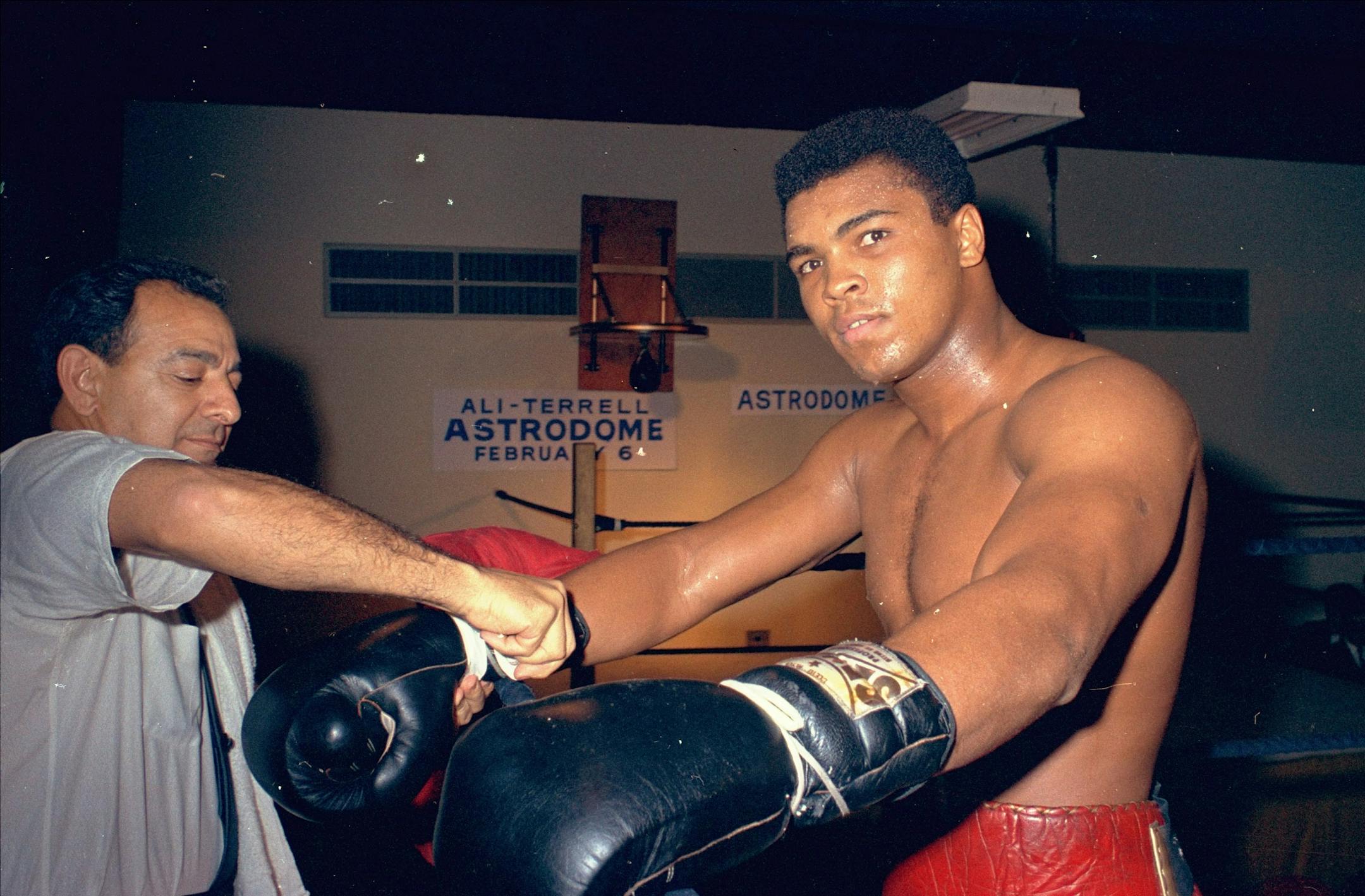 Muhammad Ali gets his gloves laced outside a boxing ring in Houston, Texas in February 1967. Ali is training for a Feb. 6 championship title fight with Ernie Terrell.