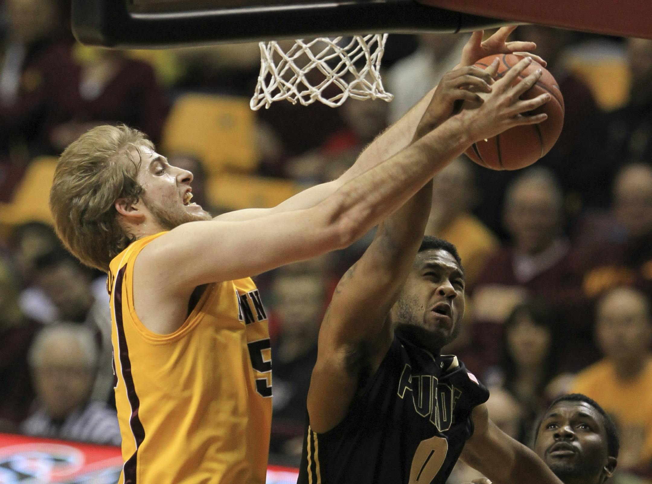 Purdue's Terone Johnson grabbed a rebound in front of the Gophers' Elliott Eliason in the first half.