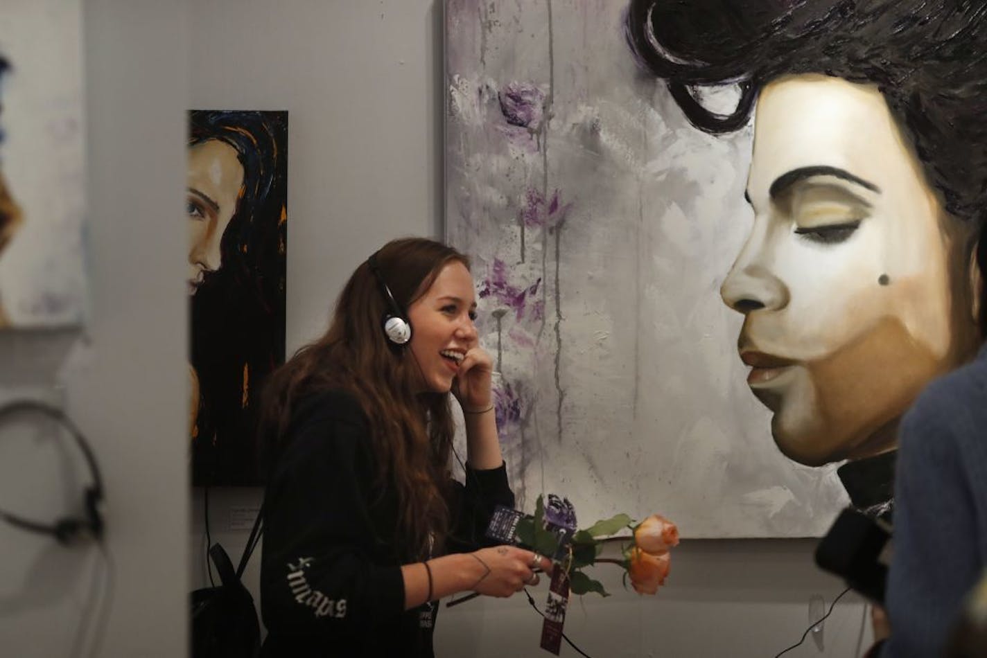 Claire Hauge enjoyed the music of Prince as she looked at the art work at Linda Clayton Fine Art during Art-A-Whirl which is presented by the Northeast Minneapolis Arts Association at the Northrup King Building Sunday May 21, 2017 in Minneapolis, MN.