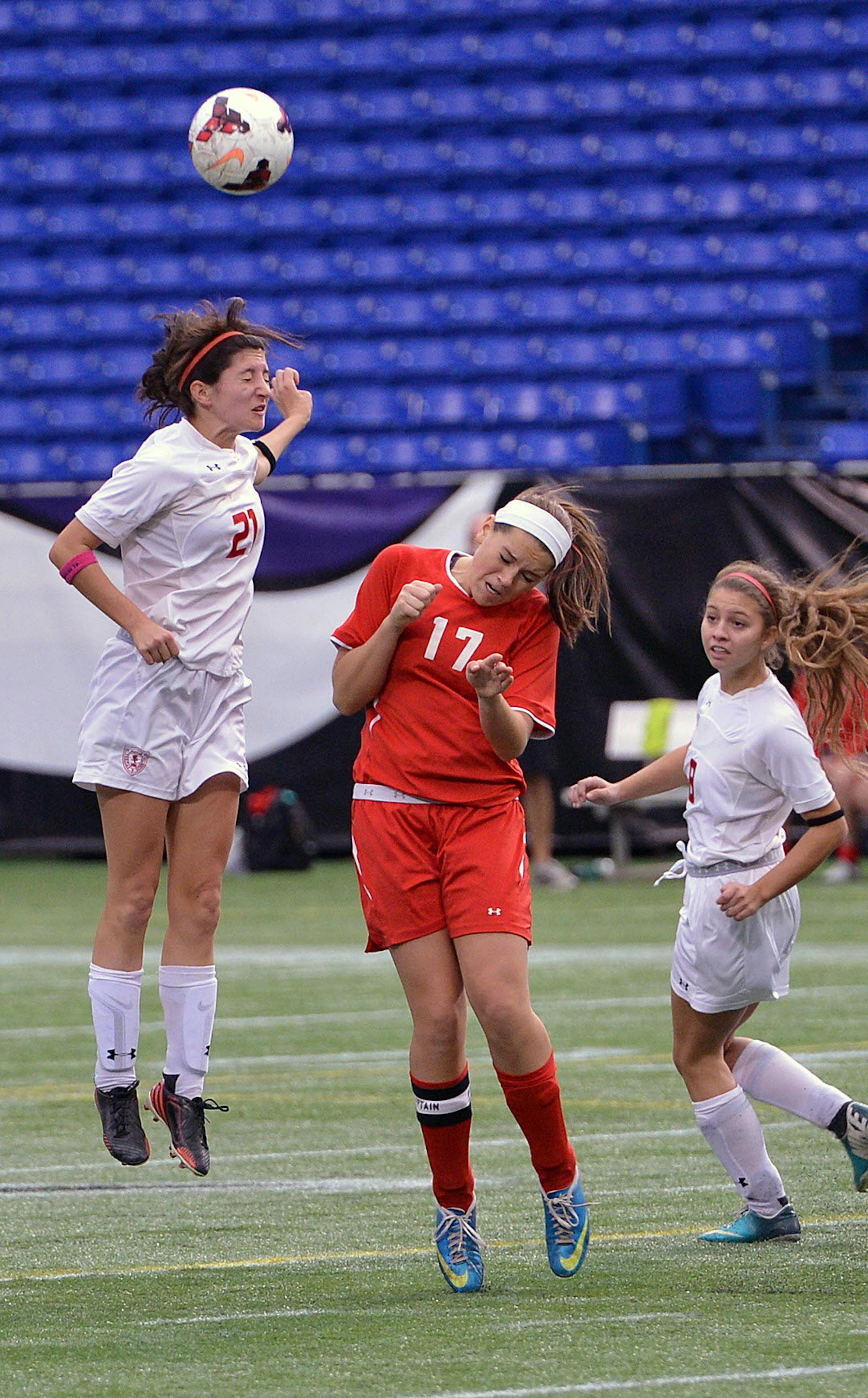 Benilde-St. Margaret defender Keara Clacko beats Manktato West's Hannah Fox to a header during the second half of the Class 1A Girls' state soccer semifinal game Monday, October 28 at Metrodome. Benilde-St. Margaret came out victorious over Mankato West, 5-1. ] (SPECIAL TO THE STAR TRIBUNE/BRE McGEE) **Keara Clacko (white, 21), Hannah Fox (red, 17)