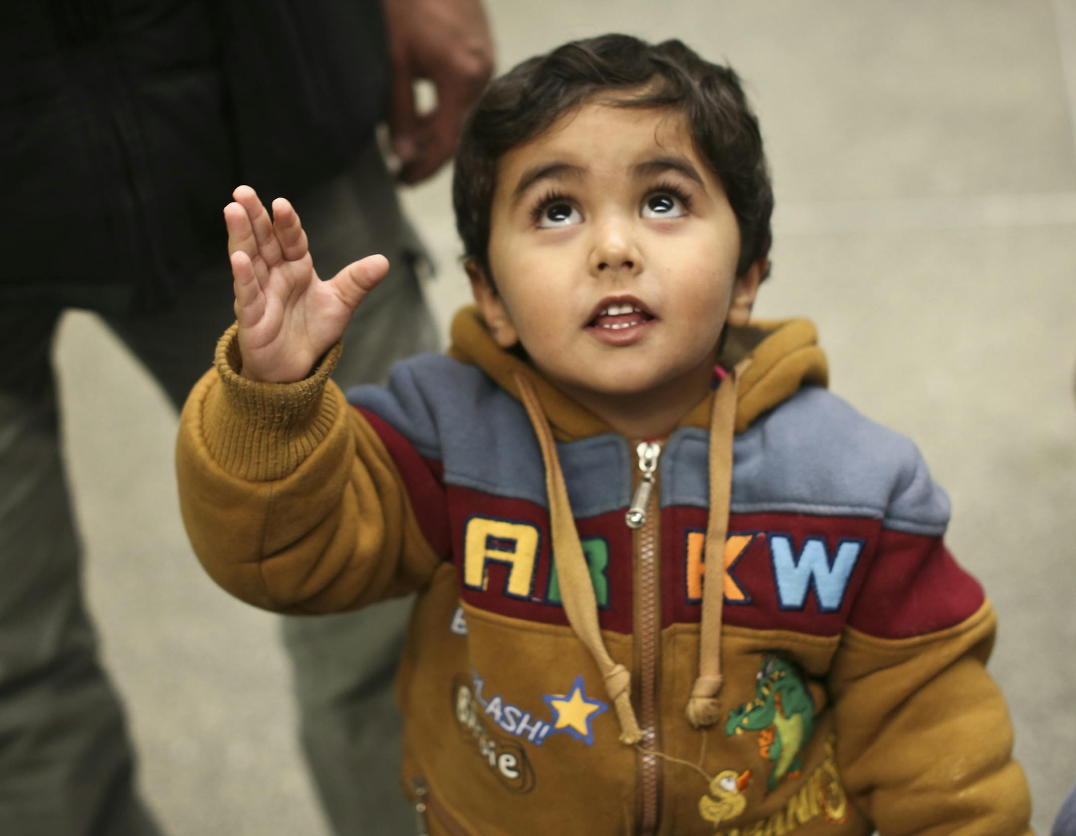 Iraqi refugee Mishaal Alkadi was reunited with the two-year-old son, Amer, at the Minneapolis/St. Paul International airport on Wednesday, April 24, 2013. His wife and the boy's mother was killed by terrorists as she and the boy waited to leave and rejoin Alkadi in the US. In this picture Amer looked up as he lost his grip of a bunch of balloons. ] (RENEE JONES SCHNEIDER * reneejones@startribune.com)