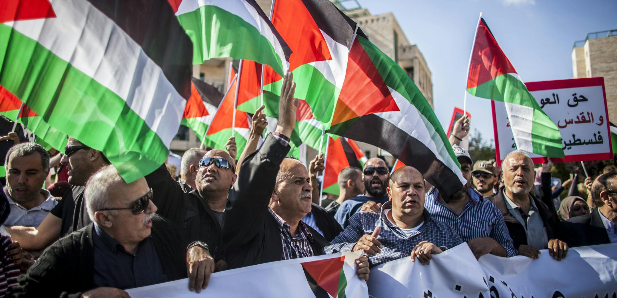 Israeli and Palestinian protestors wave signs and chant outside the new U.S. Embassy in Jerusalem Monday May 14, 2018. Israeli soldiers shot and killed dozens Palestinians during mass protests along the Gaza border on Monday. It was the deadliest day there since a devastating 2014 cross-border war and cast a shadow over Israel's festive inauguration of the new U.S. Embassy in contested Jerusalem. (AP Photo/Eyal Warshavsky)