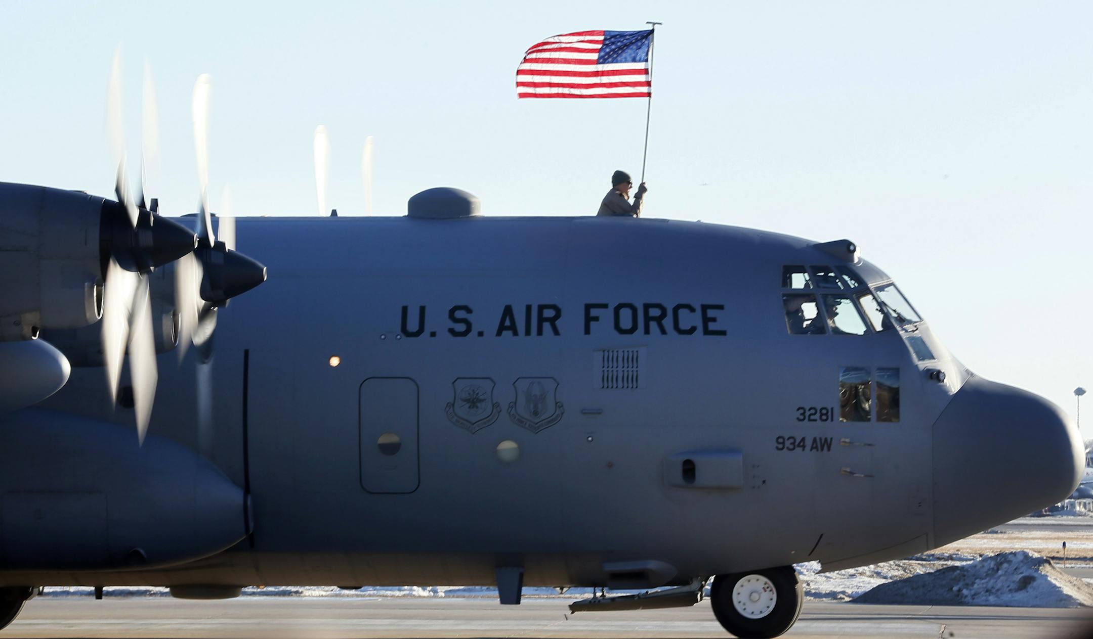 Senior Airman Brian Beckmann held the US flag as his unit arrived back in Minneapolis. Families gather for the arrival of the more than 100 Airmen and three C-130 H3 Hercules aircraft from the 934th Airlift Wing, Air Force Reserve, return from their deployment to Southwest Asia after their four-month tour of duty. Sunday January 18, 2015 Minneapolis, MN.] Jerry Holt/ Jerry.Holt@Startribune.com