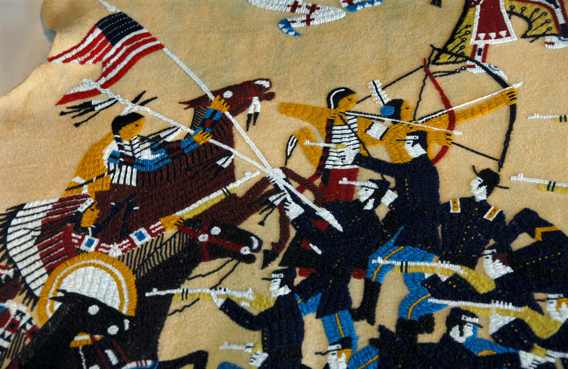 Battle scene done in beads on a hide.