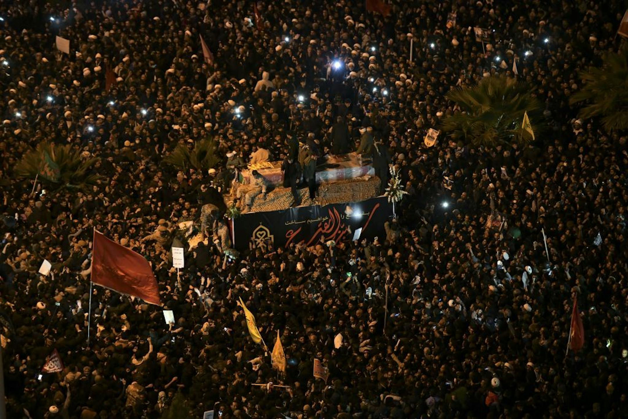Mourners surround a truck carrying the flag draped coffins of Gen. Qassem Soleimani and his comrades in the holy city of Qom south of the capital Tehran, Iran, Monday, Jan. 6, 2020. The men were killed in a U.S. drone strike on Friday, Jan. 3 in Iraq. The funeral drew a crowd said by police to be in the millions in the Iranian capital, filling thoroughfares and side streets as far as the eye could see.