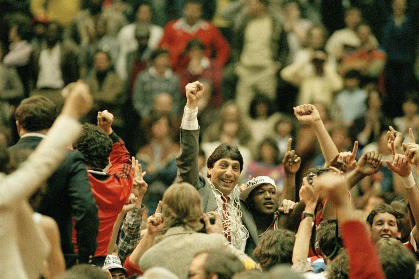 FILE - In this April 4, 1983, file photo, North Carolina State coach Jim Valvano, center with fist raised, celebrates after his basketball team defeated Houston to win the NCAA Final Four championship in Albuquerque, N.M. To this day, North Carolina State's Dereck Whittenburg jokes that his deep jumper that came up woefully short against Houston in the 1983 title game was really a perfect pass. Regardless, the Wolfpack's Lorenzo Charles was in the perfect spot to make the catch, drop the ball th