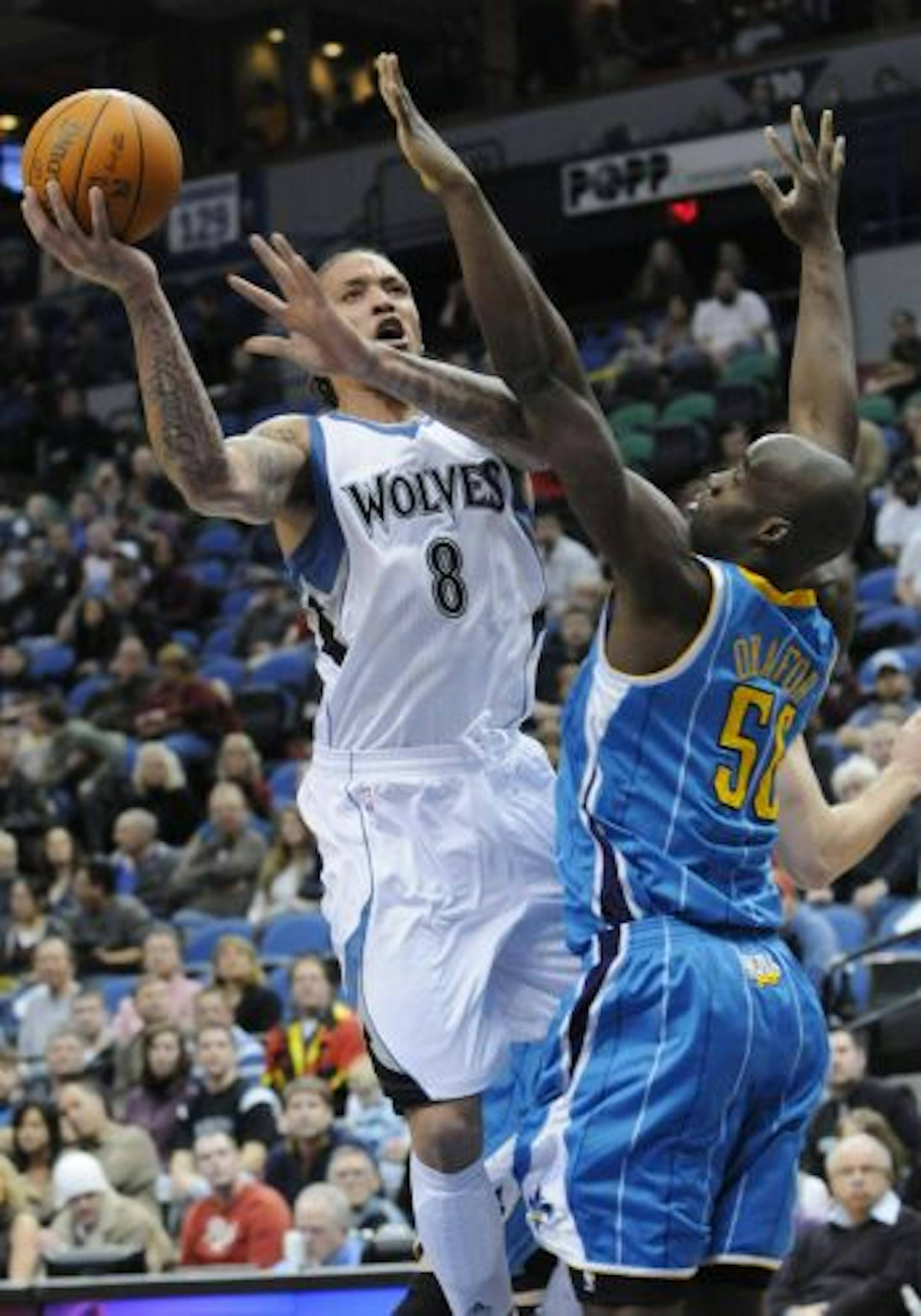 Minnesota Timberwolves' Michael Beasley, left, lays up over New Orleans Hornets' Emeka Okafor during the first half of an NBA basketball game Friday, Feb. 25, 2011, in Minneapolis.