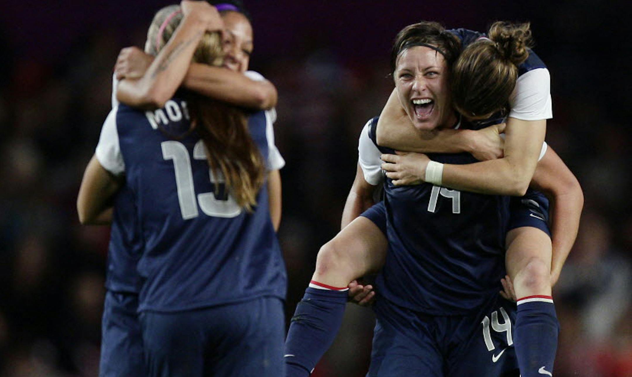 Abby Wambach, center right, celebrates with teammates including Kelley O'Hara on her back and scorer of the winning goal Alex Morgan, left with back to camera, after their 4-3 women's soccer semifinal win over Canada.