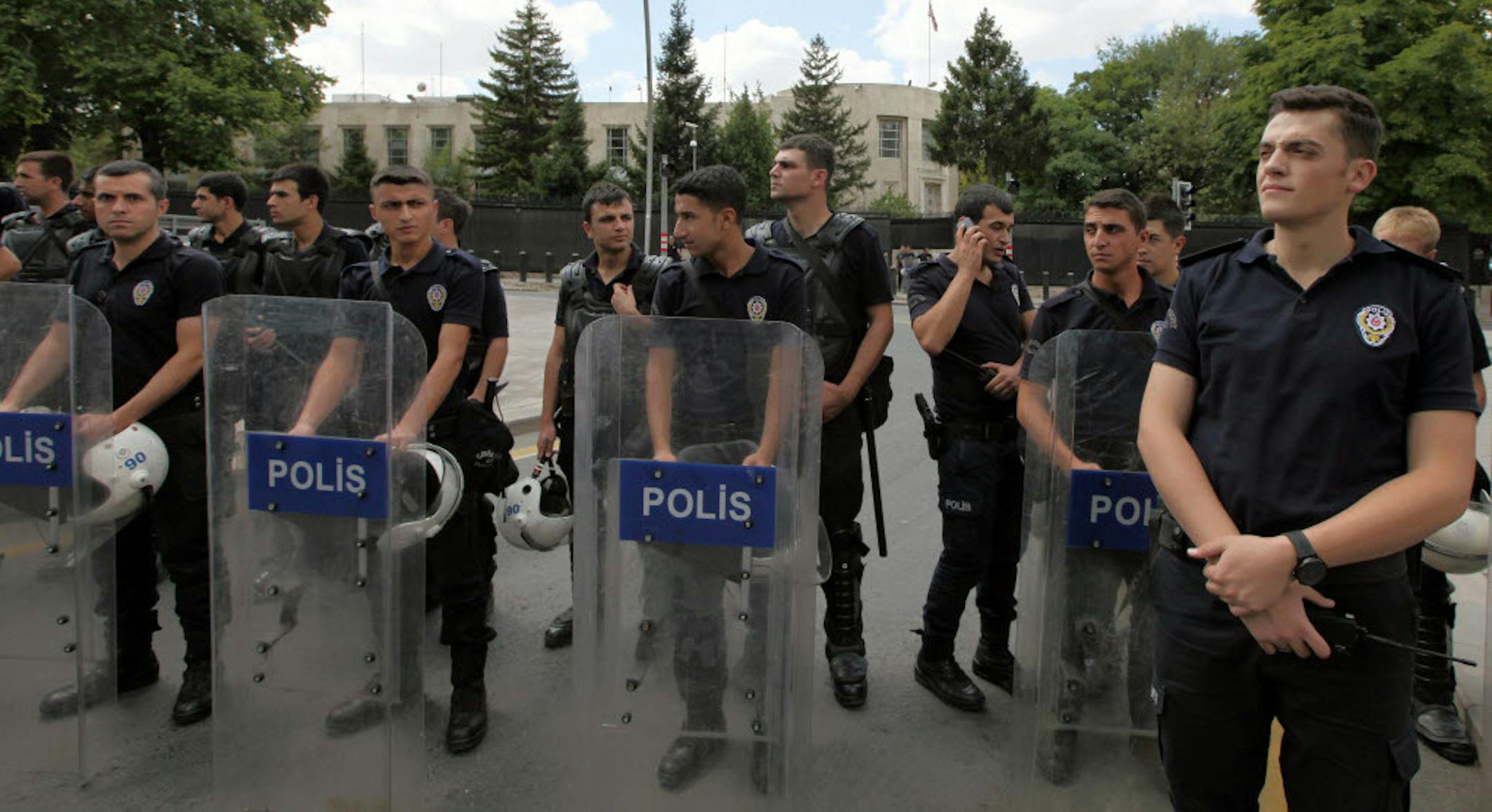 Riot police stand guard outside the U.S. embassy as Turkish supporters of Egypt's ousted President Mohammed Morsi demonstrate to condemn the latest killings in Egypt, in Ankara, July 27, 2013.