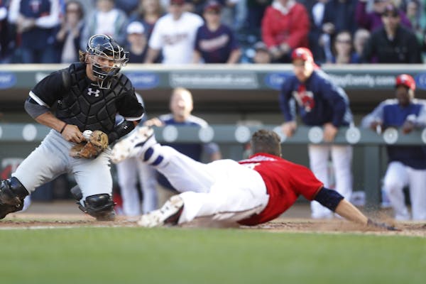 Minnesota Twins second baseman Brian Dozier (2) scored in the firth inning on Chicago White Sox catcher Kevan Smith on an inside the park home run at 