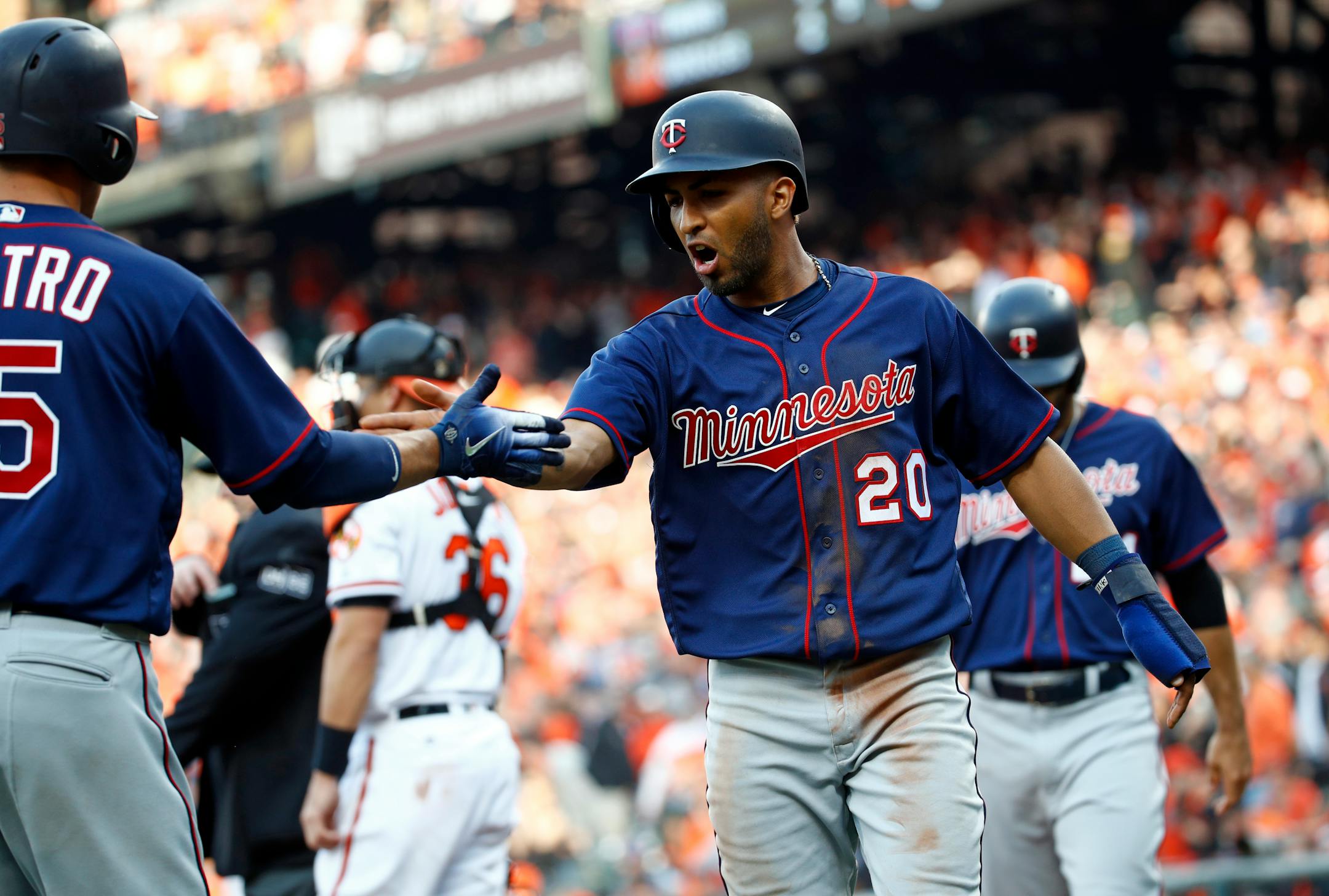 Minnesota Twins' Eddie Rosario (20) celebrates with teammate Jason Castro after scoring on a single by Robbie Grossman during the ninth inning of an opening-day baseball game Thursday, March 29, 2018, in Baltimore. Baltimore won 3-2 in 11 innings. (AP Photo/Patrick Semansky)