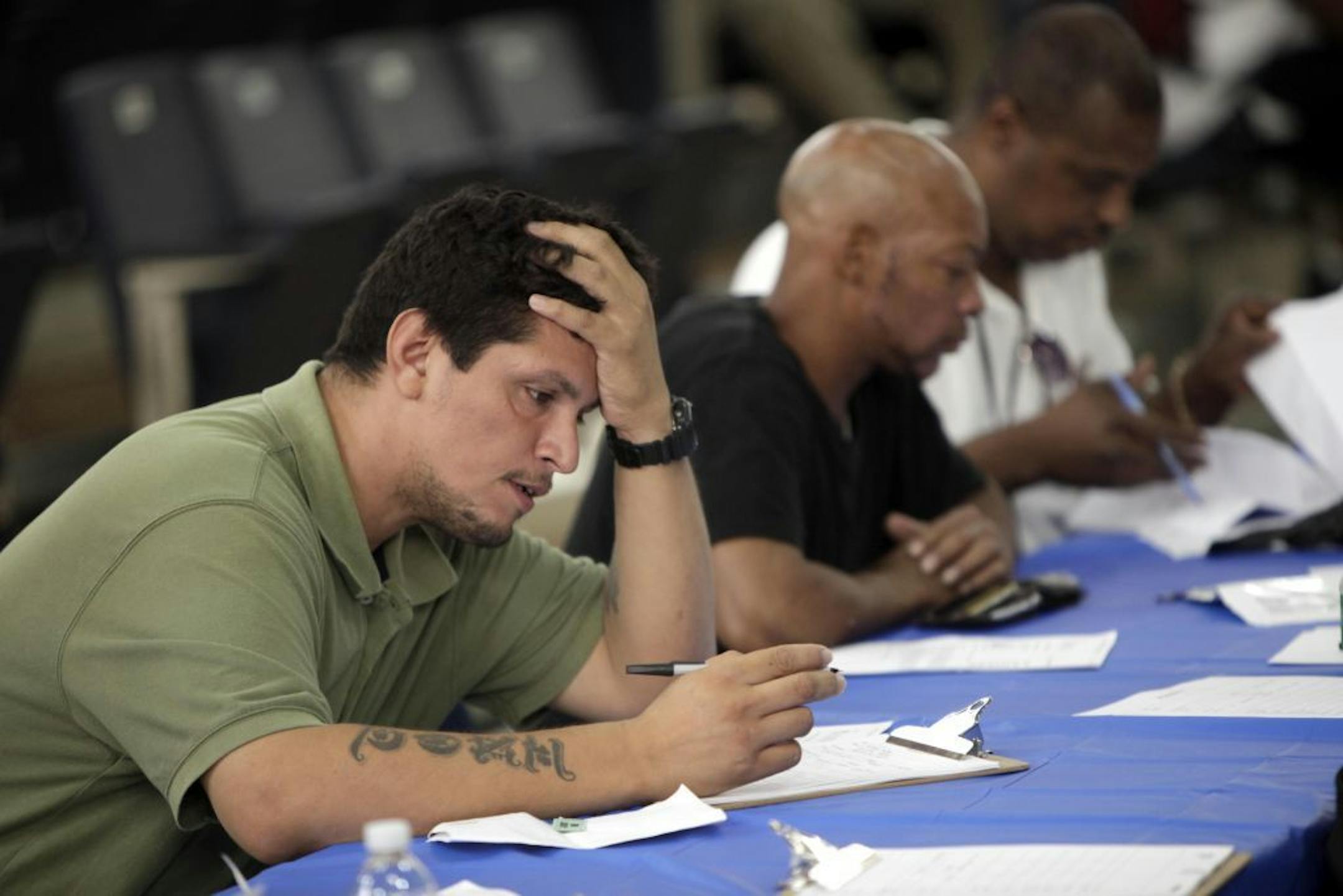 FILE - In this Tuesday, Aug. 21, 2012 file photo, job seekers fill out applications at a construction job fair in New York. U.S. employers added 96,000 jobs last month, the Labor Department said Friday, Sept. 7, 2012, a weak figure that could slow any momentum President Barack Obama hoped to gain from his speech to the Democratic National Convention.
