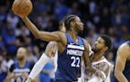 Oklahoma City Thunder forward Paul George, right, defends Minnesota Timberwolves forward Andrew Wiggins (22) in the second half of an NBA basketball g
