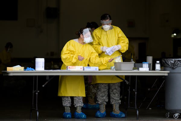 Elizabeth Santoro and Kristin Anderson, medics with the Minnesota Air National Guard 133rd Medical Group, prepared to administer COVID-19 tests at the