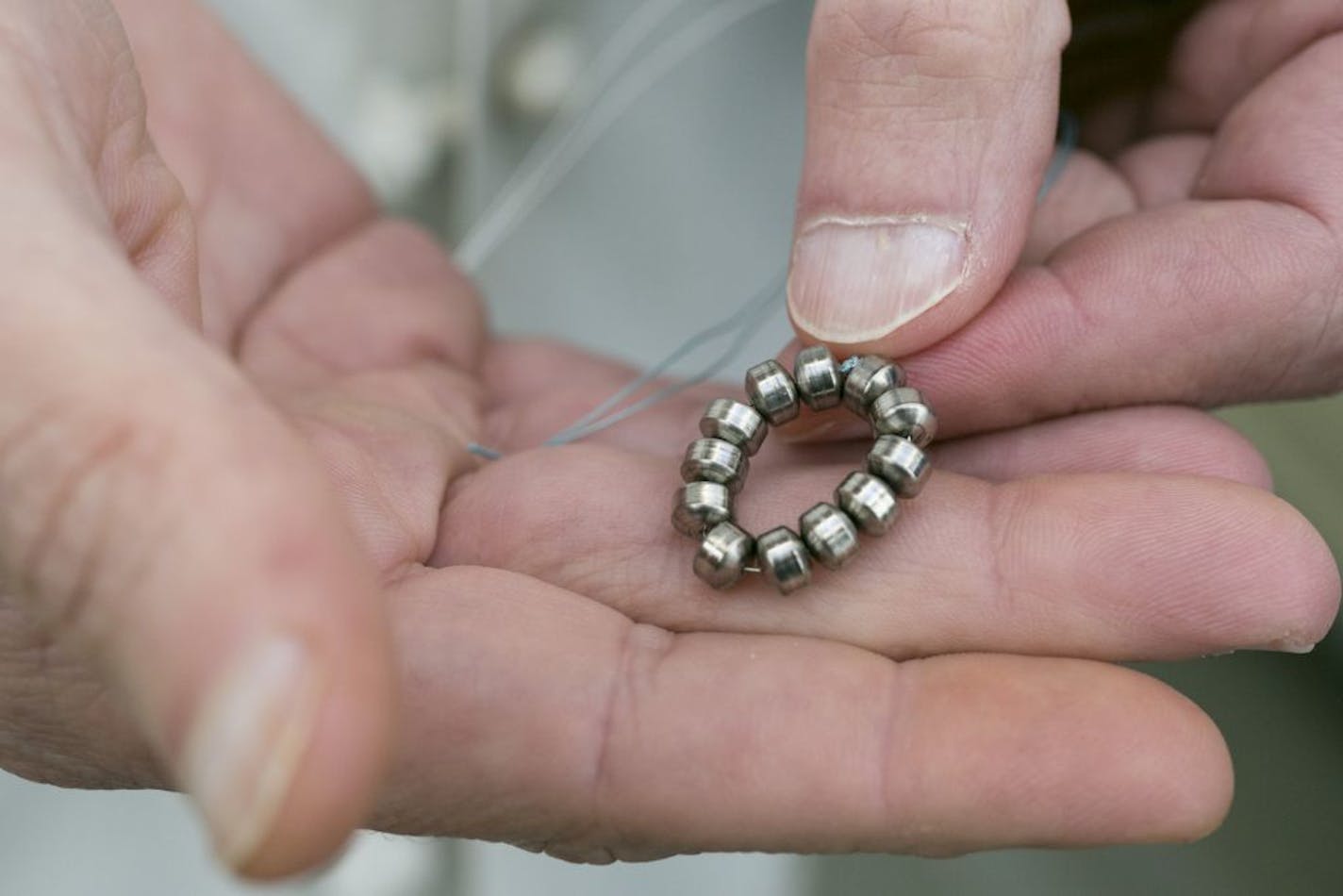 Surgeon Dr. John Lipham holds a sample Linx device at the Hoag Memorial Hospital Presbyterian in Newport Beach, Calif. on Thursday, April 4, 2013. The small band of magnetic beads is used to treat chronic heartburn. The bracelet-like device is implanted around a weak muscle at the base of the throat that doesn�t close as it should and helps prevent stomach acid from splashing back into the throat. Swallowing food will overcome the magnetic attraction and allow the beads to separate, allowing foo