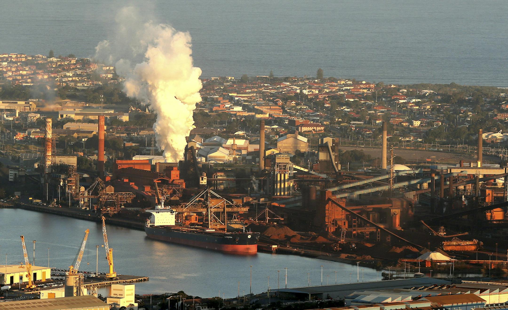 FILE - In this July 2, 2014 file photo, smoke billows out of a chimney stack of steel works factories in Port Kembla, south of Sydney. Australia's government repealed a much-maligned carbon tax on the nation's worst greenhouse gas polluters on Thursday, July 17, 2014, ending years of contention over a measure that became political poison for the lawmakers who imposed it. The Senate voted 39 to 32 to axe the 24.15 Australian dollar ($22.60) tax per metric ton of carbon dioxide that was introduced