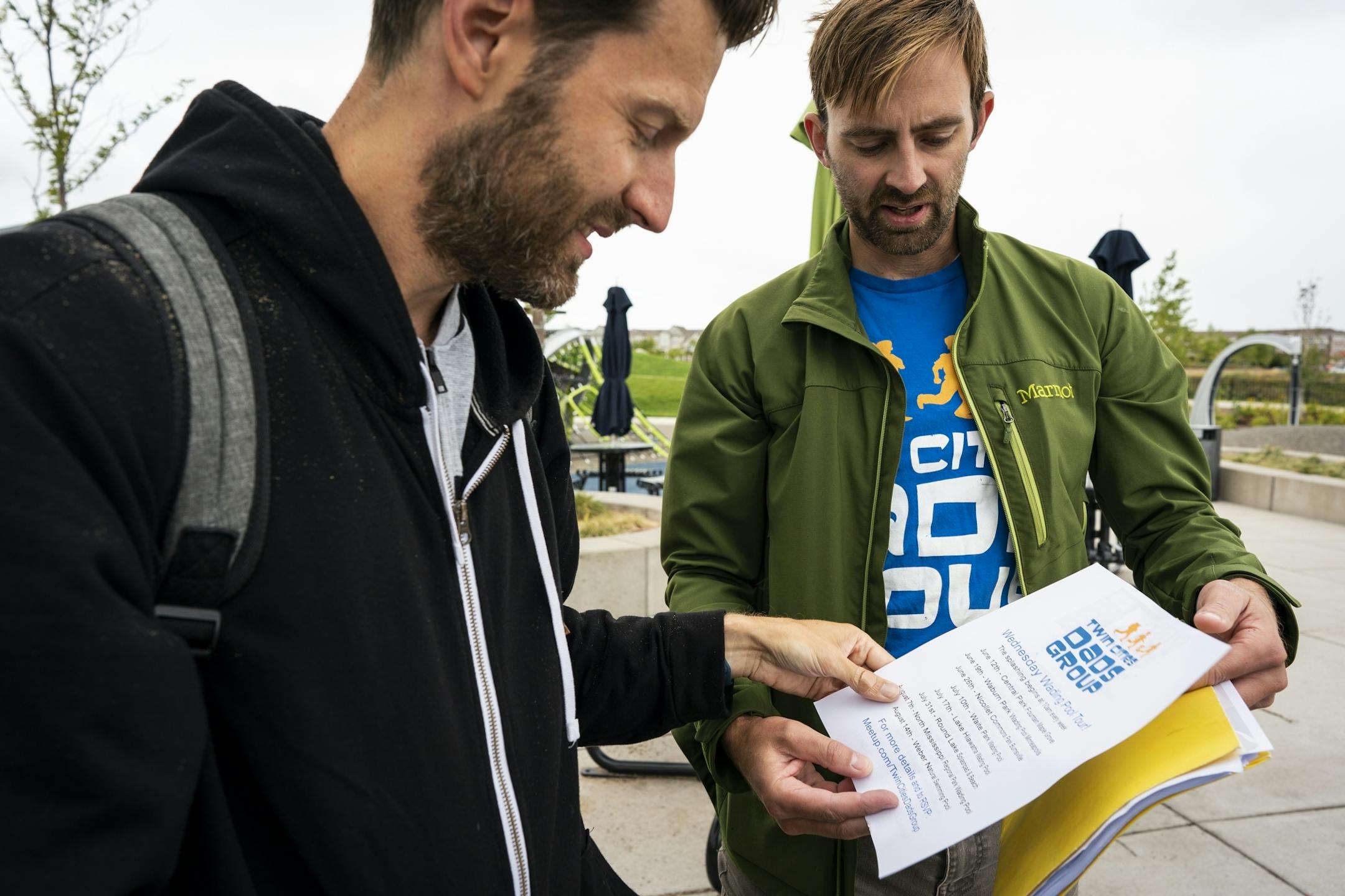 Keith Nagel, right, gives information about Twin Cities Dads to fellow stay-at-home dad John Mackenzie, left, whom he just met at Central Park.