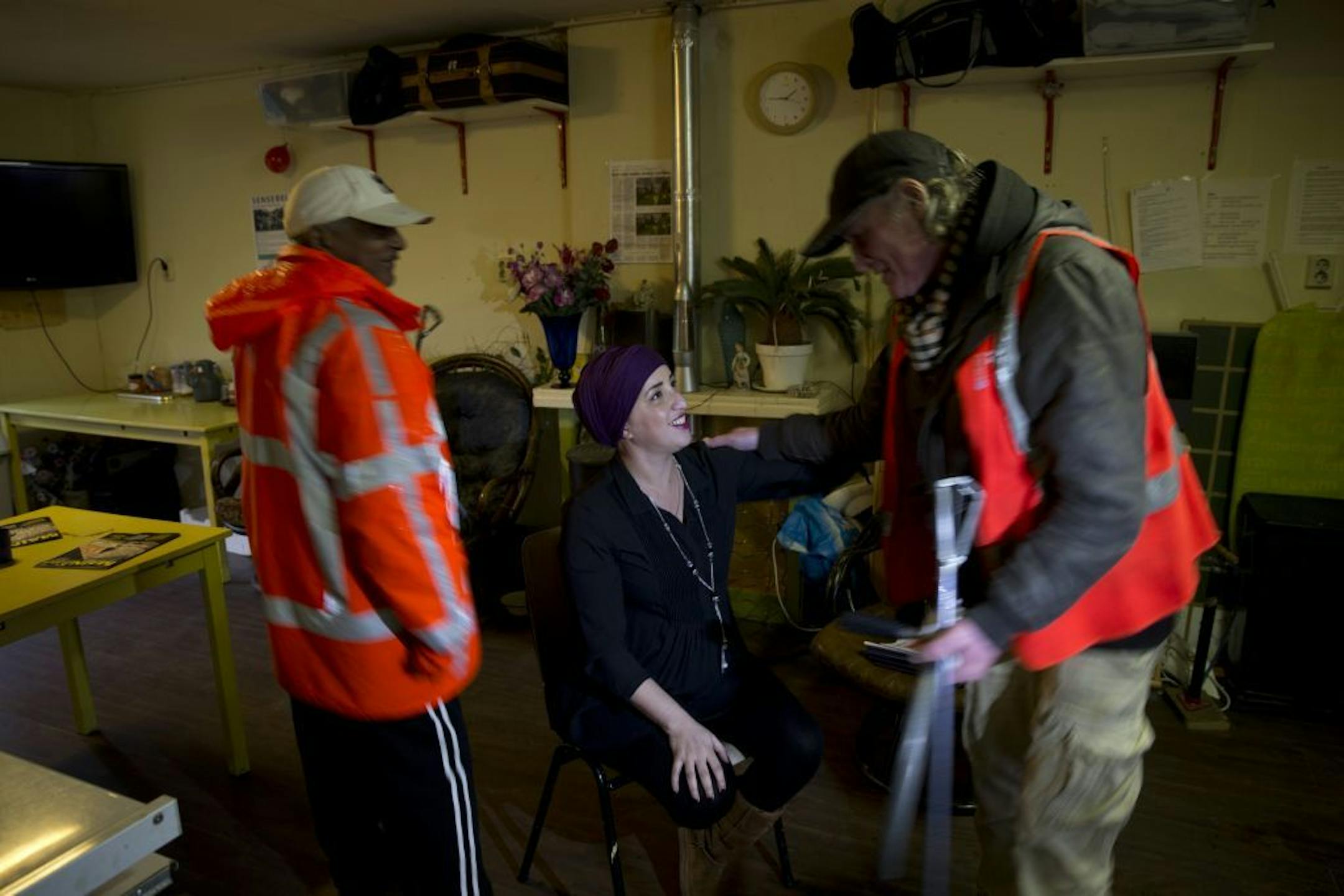 Ramon Mohamed Halim Smits, left, participant in a pilot project for alcoholics, and Simon, right, greet Amsterdam East's district mayor Fatima Elatik after returning from a cleaning round in Amsterdam, Netherlands, Wednesday Jan. 15, 2014.