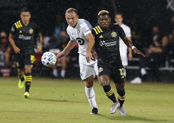 Minnesota United defender Chase Gasper (77) and Columbus Crew midfielder Luis Diaz (12) battle for the ball during the first half of an MLS soccer mat