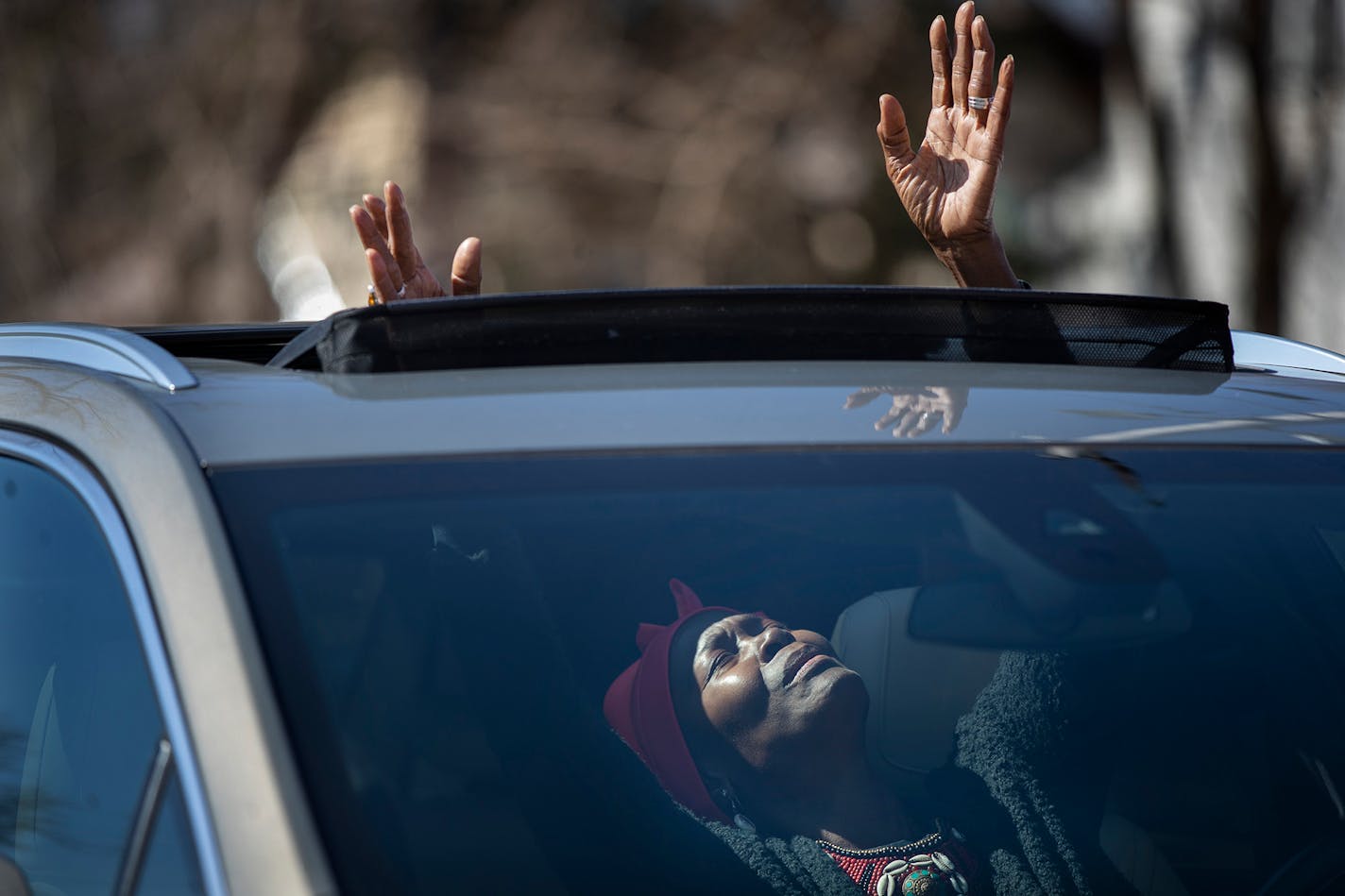 Peggie Hicks raised her hands in prayer through the sunroof of her car during the "Park and Praise" service at New Hope Baptist Church in St. Paul.