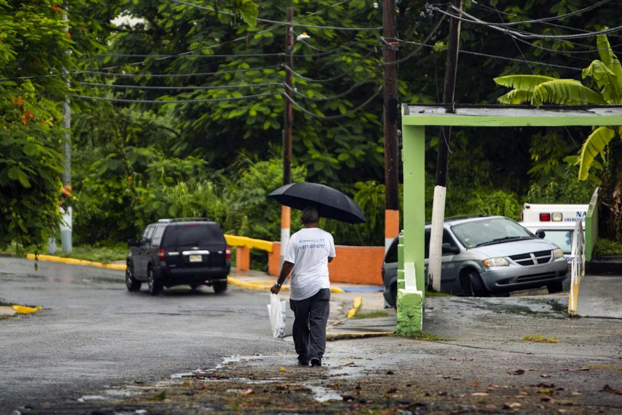 A man walks through a light rain in Naguabo, Puerto Rico, as Hurricane Dorian approaches the island on Wednesday, Aug. 28, 2019. The storm is expected to slam into the Virgin Islands and northeastern Puerto Rico on Wednesday.