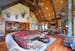 Massive stone fireplace in the living room under a reclaimed beam vaulted ceiling.