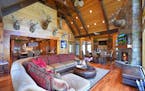 Massive stone fireplace in the living room under a reclaimed beam vaulted ceiling.