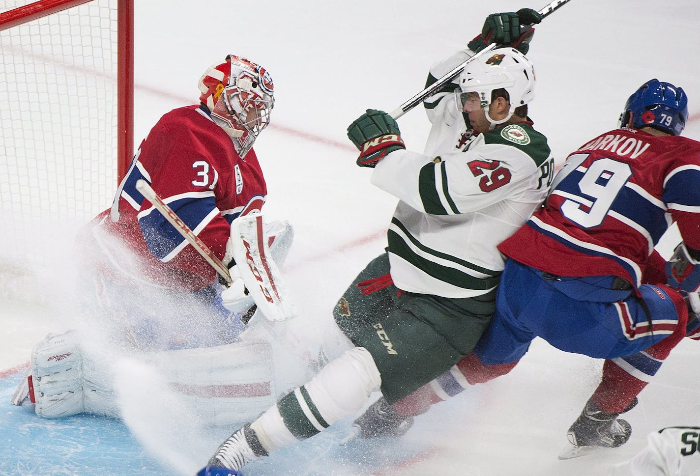 Minnesota Wild's Jason Pominville (29) slides in on Montreal Canadiens goaltender Carey Price as Canadiens' Andrei Markov (79) defends during the second period of an NHL hockey game Saturday, Nov. 8, 2014, in Montreal. (AP Photo/The Canadian Press, Graham Hughes)