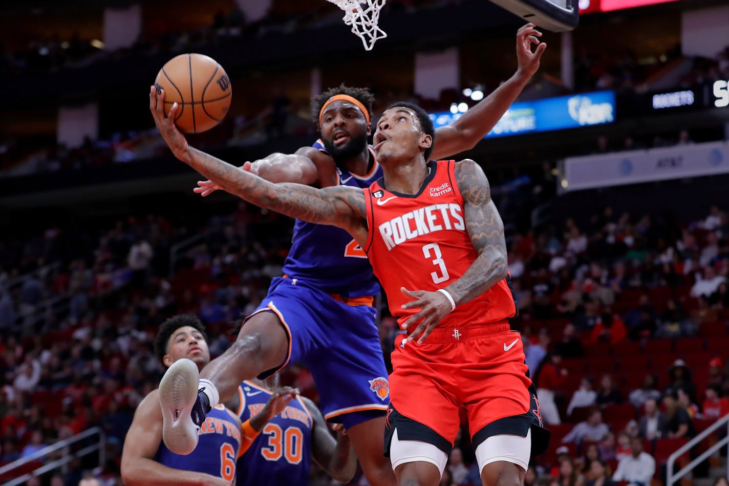 Houston Rockets guard Kevin Porter Jr. (3) shoots in front of New York Knicks center Mitchell Robinson, front left, during the second half of an NBA basketball game Saturday, Dec. 31, 2022, in Houston. (AP Photo/Michael Wyke)